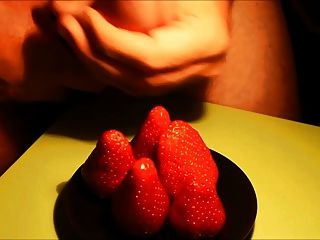 die Sahne auf Erdbeeren abspritzen