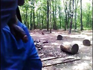 schwarzer Kerl geht im Wald mit Hahn aus